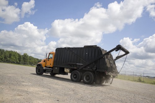 Operatives loading a skip representing rubbish removal activities